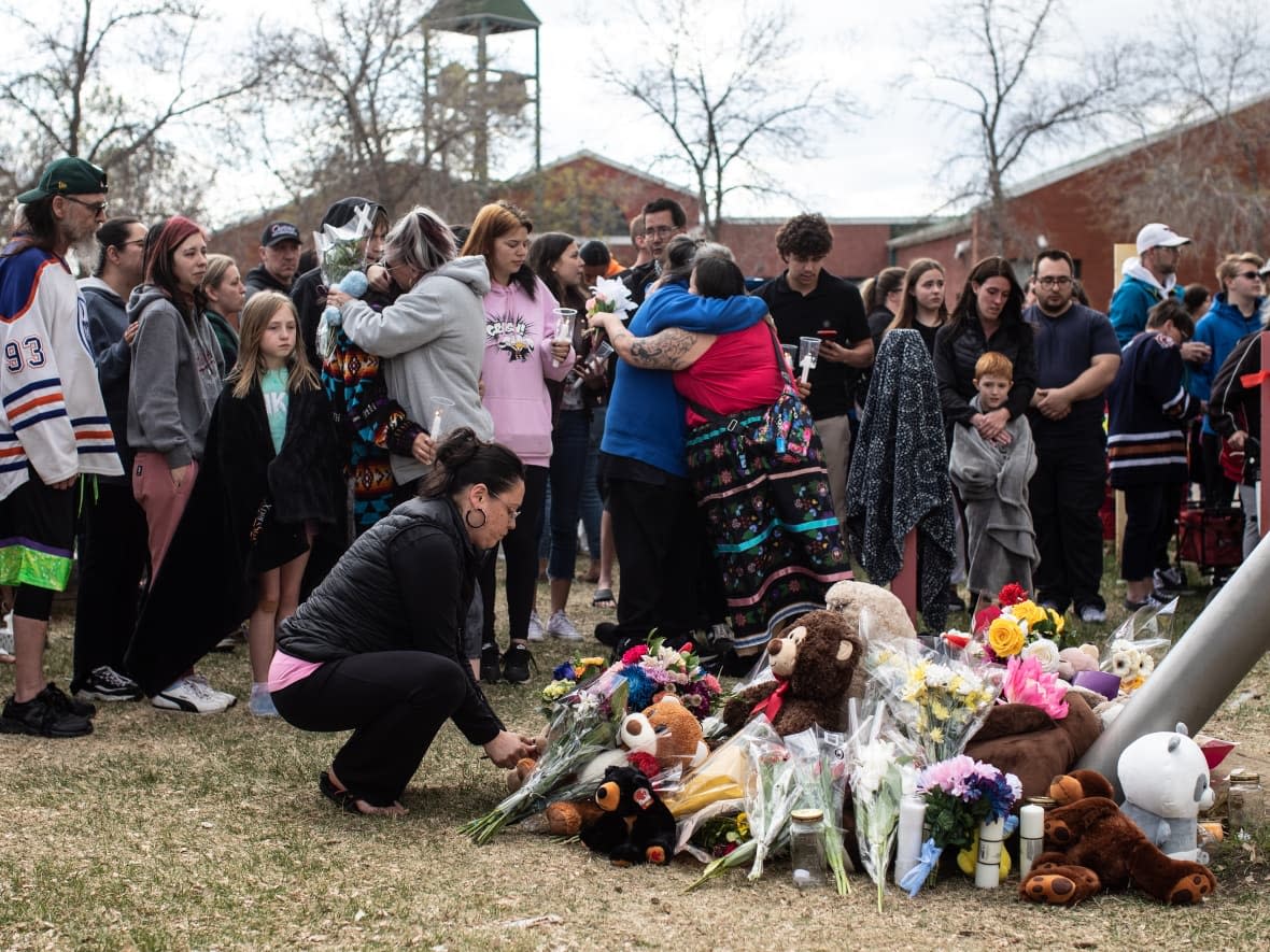 Family and friends console each other at a vigil for Carolann Robillard and her 11-year-old child Jayden Miller, who were fatally stabbed outside an Edmonton school on May 5, 2023. (Jason Franson/The Canadian Press - image credit)