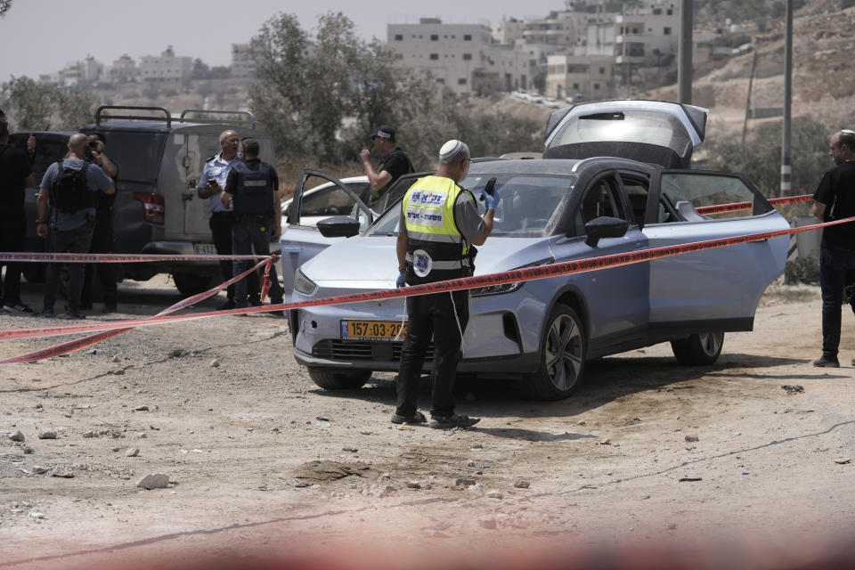 A member of Zaka Rescue and Recovery team works at the scene of a shooting attack near the West Bank city of Hebron, Monday, Aug. 21, 2023. Israeli authorities say that a suspected Palestinian attacker has killed an Israeli woman and seriously wounded a man in the incident. (AP Photo/Mahmoud Illean)