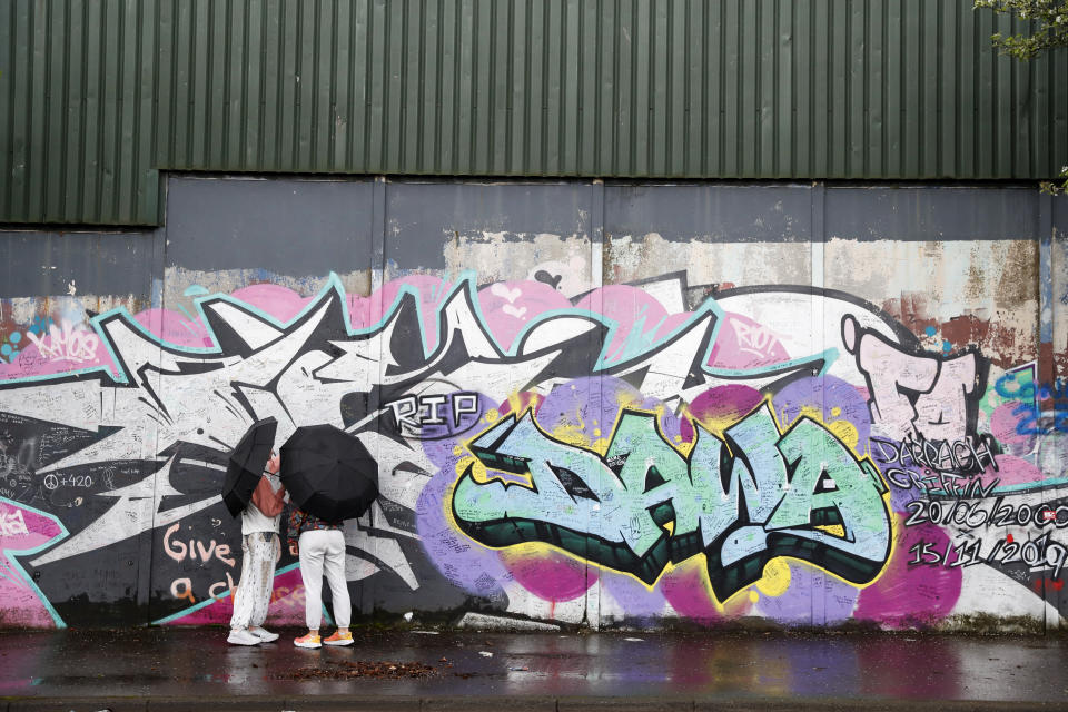Tourists visit the graffiti-covered “peace walls” that still separate some nationalist and unionist neighborhoods in west Belfast, Northern Ireland, Wednesday, April 5, 2023. It has been 25 years since the Good Friday Agreement largely a conflict in Northern Ireland that left 3,600 people dead. (AP Photo/Peter Morrison)
