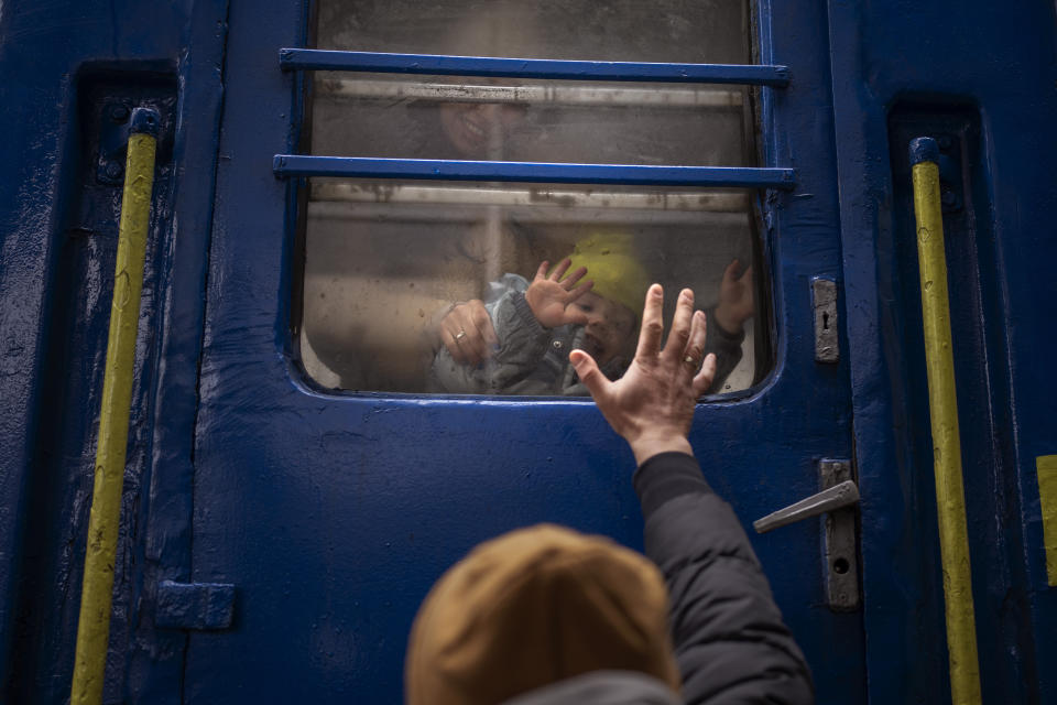 Stanislav, 40, says goodbye to his son David, 2, and his wife, Anna, 35, at a train station in Kyiv Thursday. Stanislav is staying to fight while his family is leaving to seek refuge in a neighboring country. 