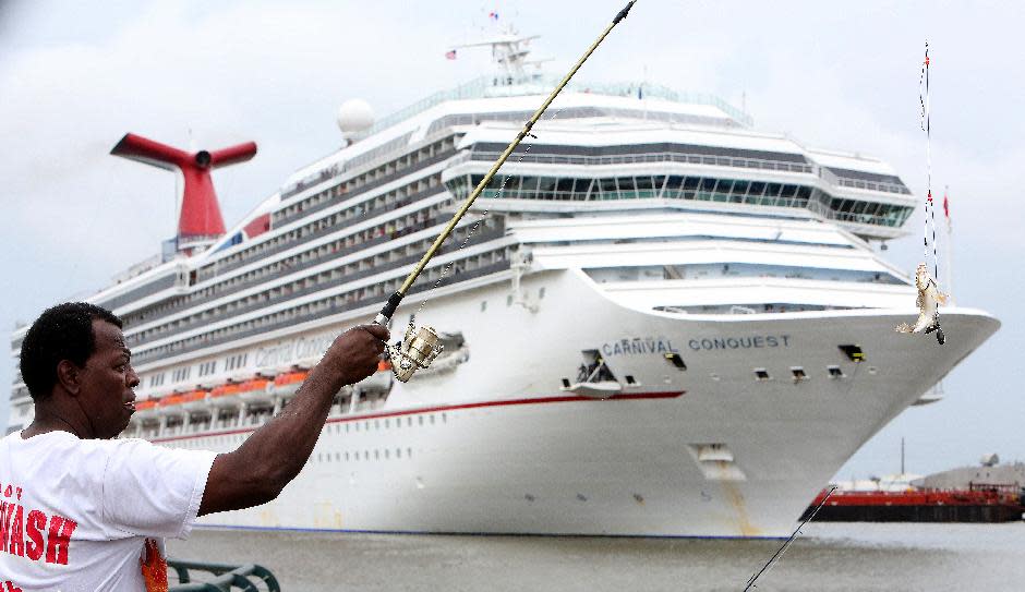 Clyde Hall of Mobile, Ala., catches a fish as the Carnival Conquest cruise ship moves down the Mobile River after turning around to dock at the Alabama Cruise Terminal on the Mobile River on a rainy Sunday, July 7, 2013, in downtown Mobile. The Conquest was diverted from New Orleans to Mobile after a tugboat sank in the Mississippi River Saturday, closing the river. (AP Photo/AL.com, Mike Brantley)