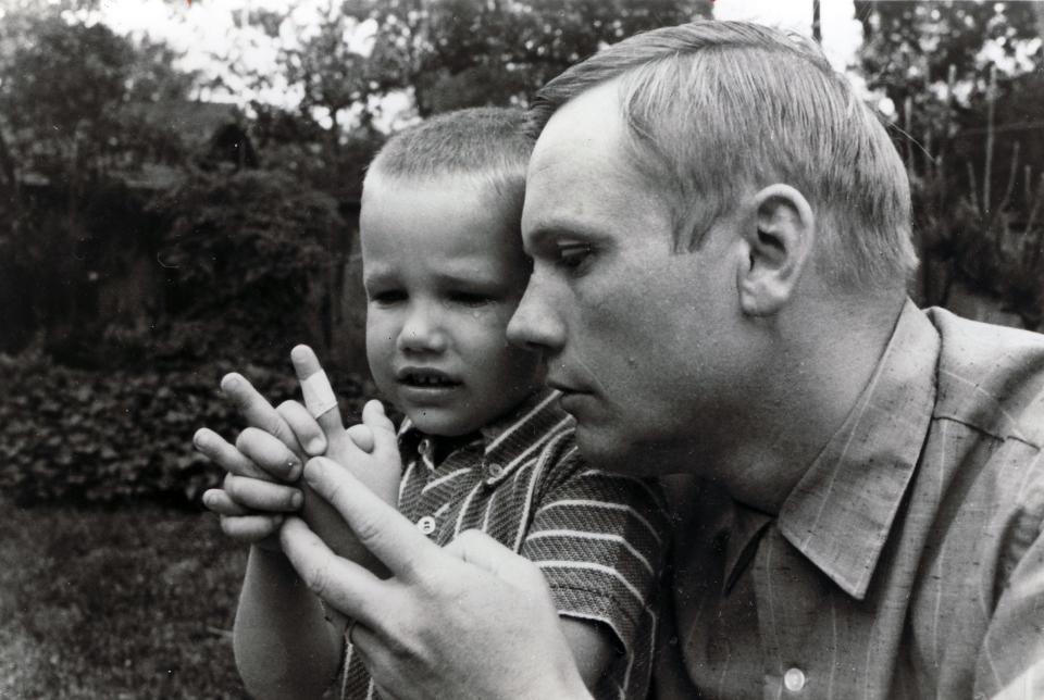In this 1969 photo, Mark Armstrong, then 6, is comforted by his father Neil Armstrong after cutting his hand in a backyard accident.