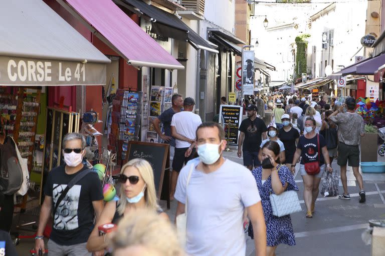 Una calle comercial con turistas en Ajaccio (Photo by Pascal POCHARD-CASABIANCA / AFP)