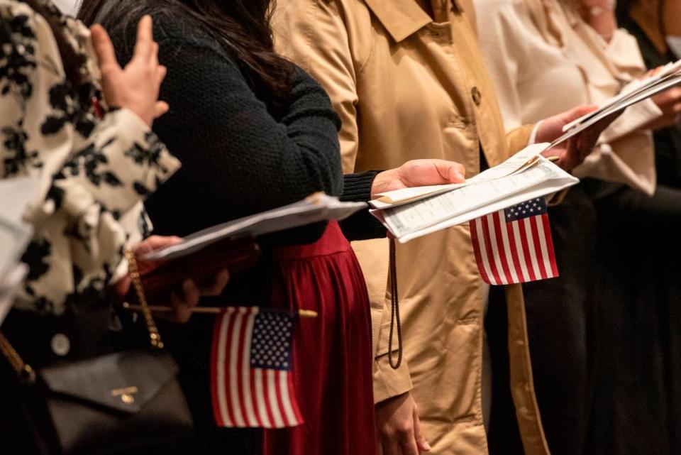 Newly naturalized American citizens do the pledge of allegiance during a naturalization ceremony at Dan M. Russell Courthouse in Gulfport on Thursday, Oct. 19, 2023.