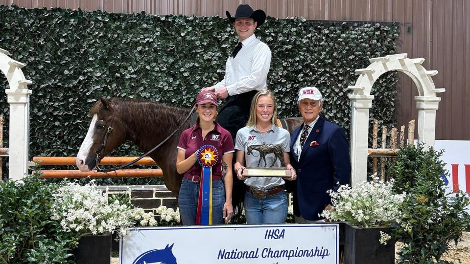 Celebrating with national champion Marty Kacsh, sitting astride his horse, are West Texas A&M University Equestrian coaches Julia Bastian and Maggie Murphy, and Intercollegiate Horse Show Association founder Bob Cacchione.