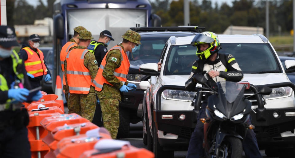 Photo shows police and ADF members at a traffic stop.