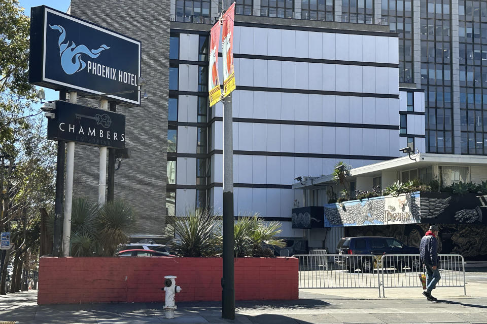 A pedestrian walks in front the Phoenix Hotel in the Tenderloin neighborhood of San Francisco, Thursday, March 14, 2024. Two hotels and unnamed residents of one of San Francisco's most problematic neighborhoods for drug use and tent encampments sued the city Thursday, demanding that city officials stop using the district as a containment zone. (AP Photo/Jeff Chiu)