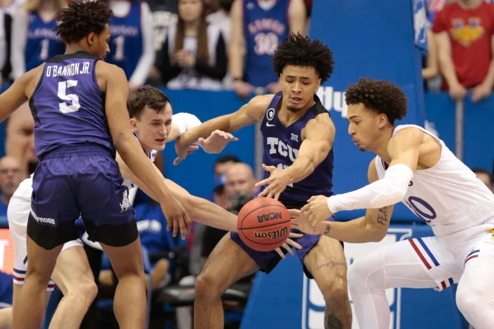 Kansas redshirt sophomore forward Jalen Wilson (10) works with super-senior forward Mitch Lightfoot (44) to steal the ball from TCU during the first half of Thursday's game inside Allen Fieldhouse.