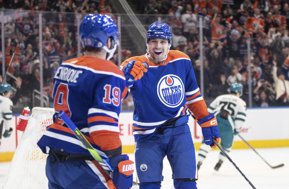 Edmonton Oilers' Adam Henrique (19) and Cody Ceci (5) celebrate a goal against the San Jose Sharks during the second period of an NHL hockey game in Edmonton, Alberta, on Monday, April 15, 2024. (Jason Franson/The Canadian Press via AP)