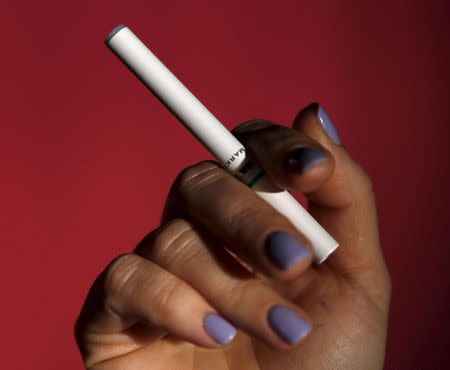 A person holds an electronic MarkTen cigarette as seen in this photo illustration shot in Washington March 17, 2015. REUTERS/Gary Cameron