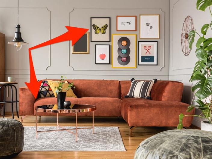 brown couch and gallery wall with arrows pointing to them