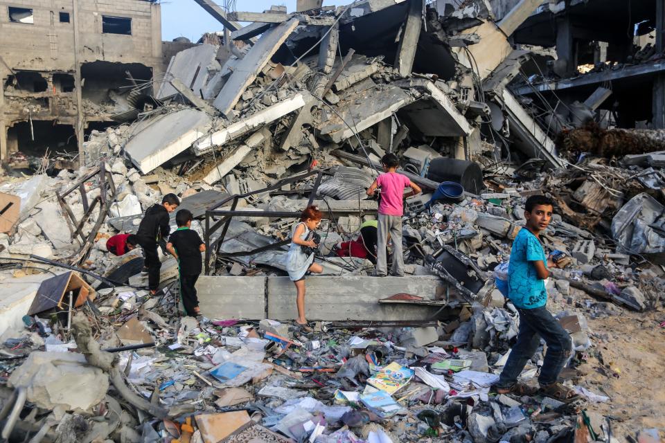 Children search through buildings, destroyed during Israeli air raids in the southern Gaza Strip on November 8, 2023 in Khan Yunis, Gaza.