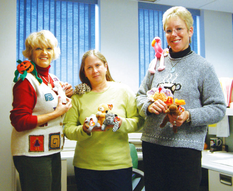 Three woman hold their collection of beanie babies