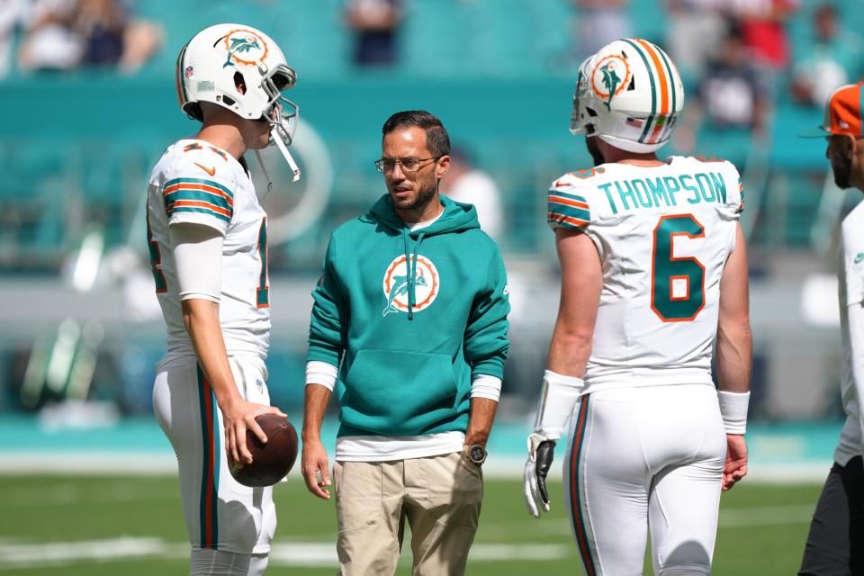 Miami Dolphins coach Mike McDaniel talks with QBs Mike White (14) and Skylar Thompson before a game vs. New England.