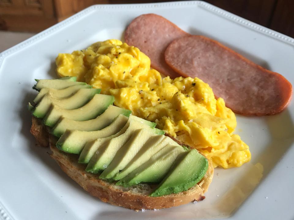 Avocado on toast, scrambled eggs, and turkey bacon.