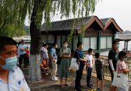 People wearing protective masks line up in the park at Summer Palace on a public holiday, after a new outbreak of the coronavirus disease (COVID-19), in Beijing