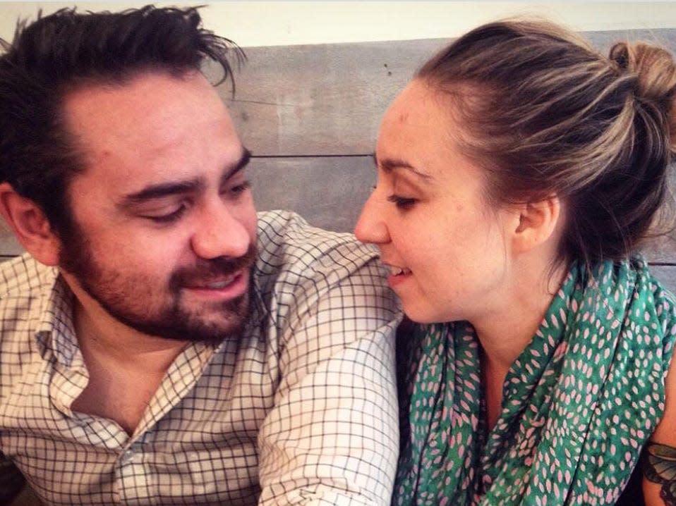 Melissa Petro and her husband sitting in a booth at a restaurant looking at each other