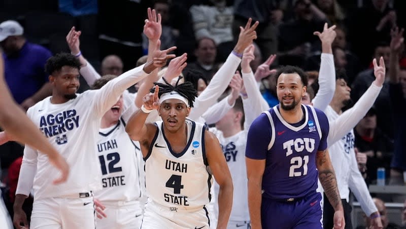 Utah State guard Ian Martinez (4) celebrates in front of TCU forward JaKobe Coles (21) after making a 3-point basket against TCU in a first-round game in the NCAA Tournament, Friday, March 22, 2024, in Indianapolis.