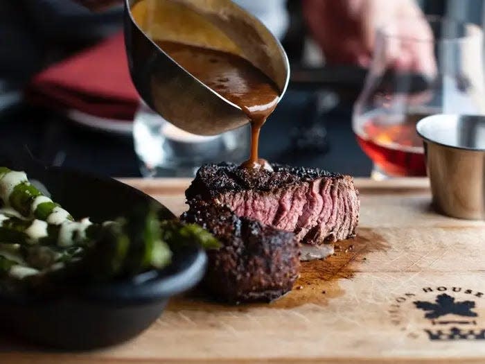 gravy being poured on to a steak