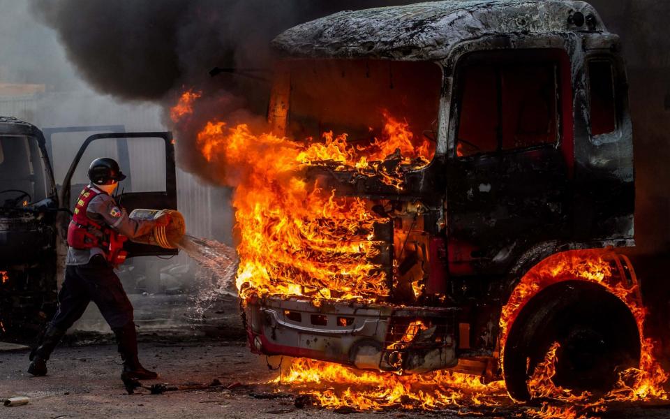 Emergency personnel try to extinguish a burning truck during a demonstration against the Venezuelan government in Caracas - EFE