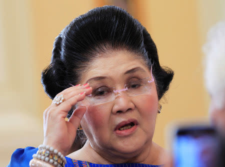 FILE PHOTO: Former Philippine first lady Imelda Marcos, who is now a congresswoman, adjusts her glasses after attending the first Mass of the newly built Santuario de San Ezekiel Moreno Catholic church in Las Pinas city, south of Manila, August 19, 2014. REUTERS/Romeo Ranoco/File Photo