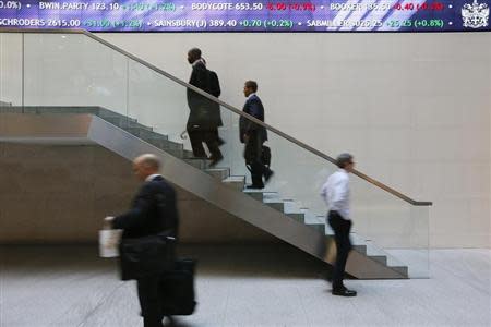 People walk past an electronic information board at the London Stock Exchange in the City of London October 11, 2013. REUTERS/Stefan Wermuth