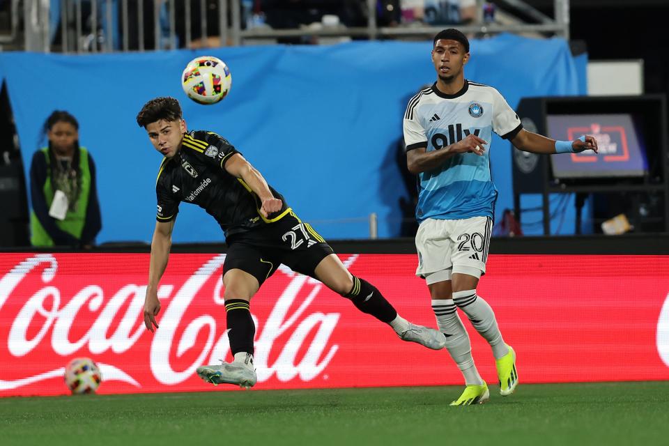 Mar 23, 2024; Charlotte, North Carolina, USA; Columbus Crew forward Max Arftsen (27) kicks the ball past Charlotte FC defender Joao Pedro (20) at Bank of America Stadium. Mandatory Credit: Cory Knowlton-USA TODAY Sports