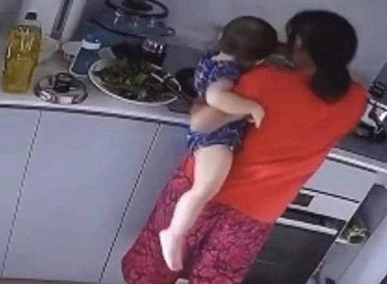 A screengrab of the CCTV recording showing the maid supposedly dipping the baby's hand into a pot. (PHOTO: Facebook)