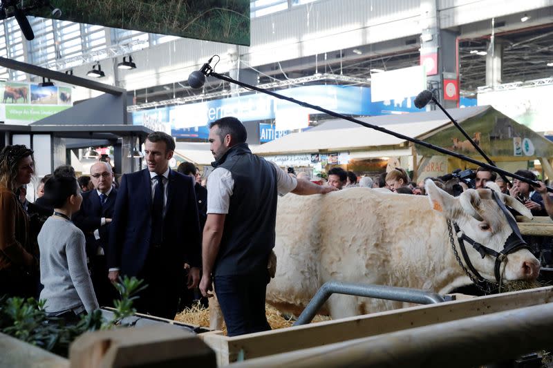 French President Emmanuel Macron speaks with a farmer during a visit to the 57th International Agriculture Fair (Salon international de l'Agriculture) at the Porte de Versailles exhibition center in Paris