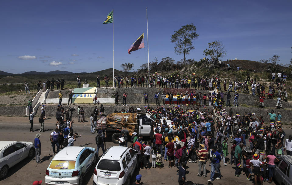 Venezolanos rodean el primer camión con ayuda humanitaria del gobierno brasileño que llegó a Paracaima, en el estado de Roraima, Brasil, en la frontera con Venezuela, el sábado 23 de febrero de 2019. (AP Foto/Iván Valencia)