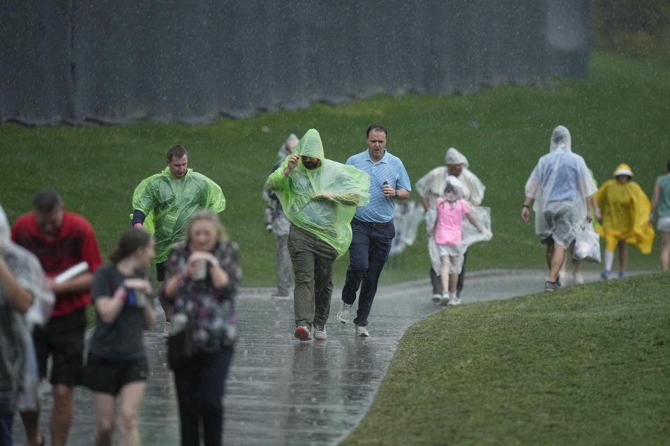 Golf fans leave the course after play was suspended for weather in the second round of the Players Championship golf tournament Friday, March 10, 2023, in Ponte Vedra Beach, Fla. (AP Photo/Eric Gay)