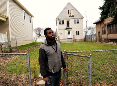 Brandon who was hospitalized for severe lead poisoning from paint chips when he was one, almost 20 years ago stands in front of the house where he lived in Milwaukee, Wisconsin, U.S. November 30, 2016. REUTERS/Darren Hauck