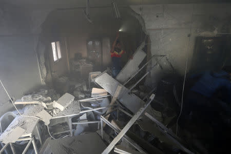 A Palestinian man gestures as he inspects a building hit by an Israeli air strike, in the southern Gaza Strip May 5, 2019. REUTERS/Ibraheem Abu Mustafa