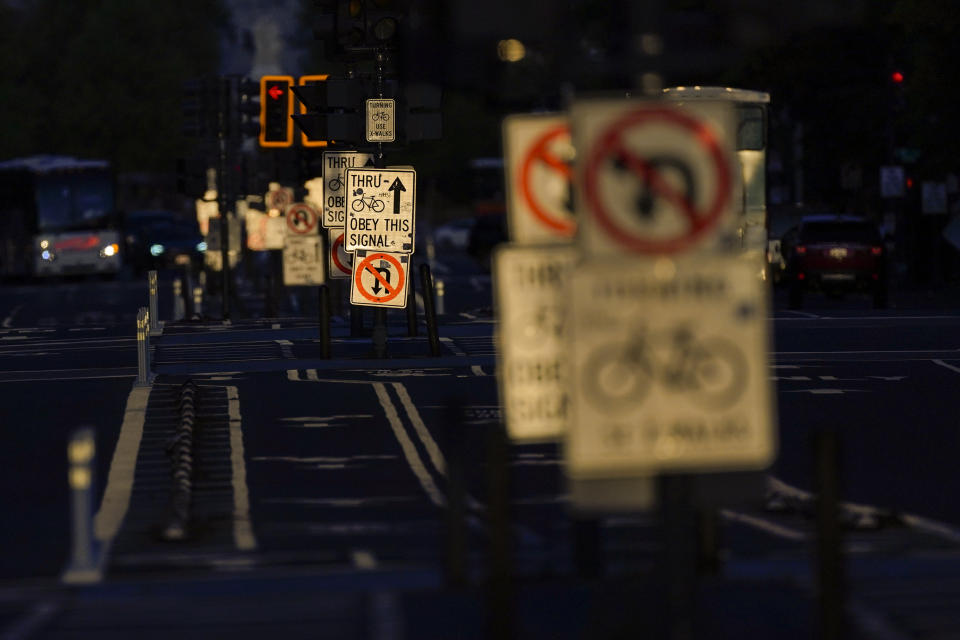 Bike lane signs are reflected in the setting sun along Pennsylvania Avenue in Washington, Monday, May 8, 2023. (AP Photo/Carolyn Kaster)