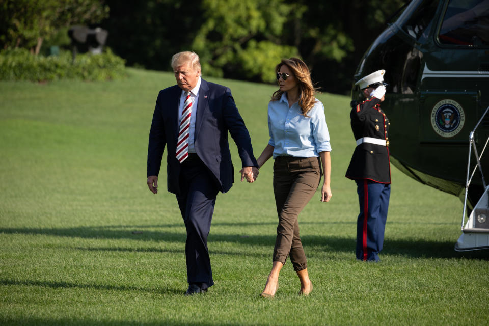 No stranger to chic travel gear, the First Lady landed at the White House in a crisp blue shirt tucked into khaki trousers. [Photo: Getty]