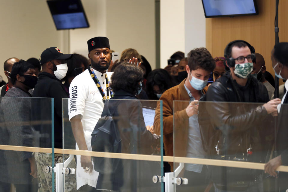 Congolese activist Mwazulu Diyabanza, center left, arrives at the Palais de Justice courthouse, in Paris, Wednesday, Sept. 30, 2020. The controversial Congolese activist and four others are going on trial Wednesday on aggravated theft charges for trying to remove a 19th century African funeral pole from a Paris museum, in a protest against colonial-era plundering of African art. (AP Photo/Thibault Camus)