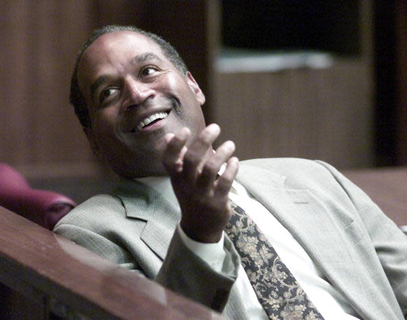 395698 11: Former NFL star O.J. Simpson talks to someone before the start of the third day of jury selection in a “road rage” trial October 11, 2001 in Miami, FL. Simpson is on trial for allegedly attacking a Miami motorist December 4, 2000. If found guilty, Simpson faces up to 16 years in prison. (Pool Photo By Wilfredo Lee/Getty Images)