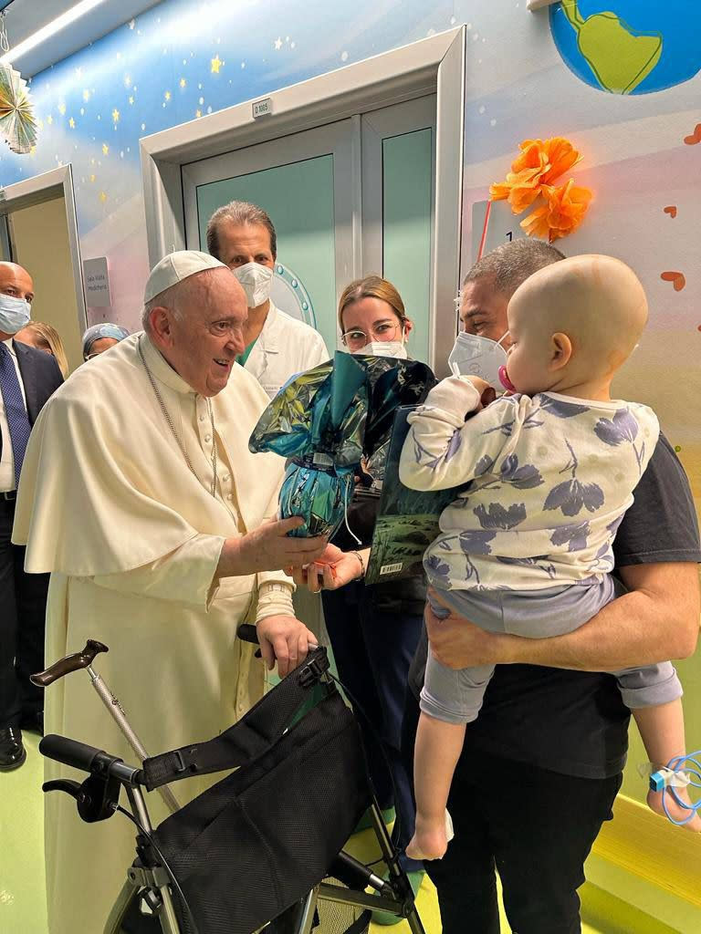 In this image made available by Vatican Media, Pope Francis brings Easter eggs to the young patients of the pediatric oncology ward, Friday, March 31, 2023 inside the Agostino Gemelli University Hospital where he is treated since Wednesday for a bronchitis. Francis is expected to be discharged on Saturday. (AP Photo/Vatican Media)