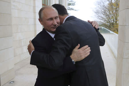 FILE PHOTO: Russian President Vladimir Putin (L) welcomes Syrian President Bashar al-Assad during a meeting in the Black Sea resort of Sochi, Russia November 20, 2017. Sputnik/Mikhail Klimentyev/Kremlin via REUTERS/File Photo