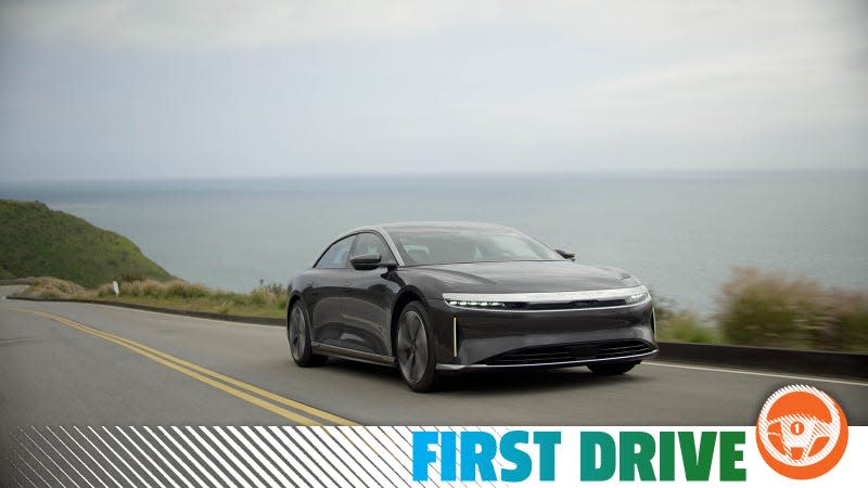 A black 2023 Lucid Air Touring drives along the coast.