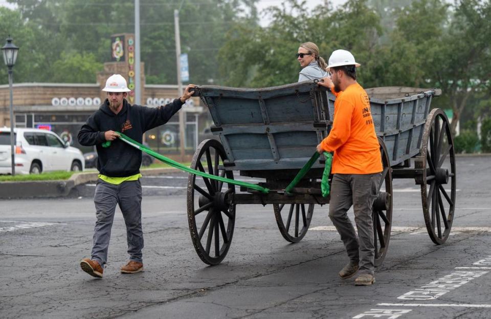 Mercedes Chastain, daughter of Cooper Weeks, owner of the Old Westport Shopping Center, sat in a replacement covered wagon as crews from Infinity Sign Co. rolled it into place. The replica wagon, built for the 1976 bicentennial, replaces an 1860s covered wagon that had been at Westport Road and Southwest Trafficway since 1963.