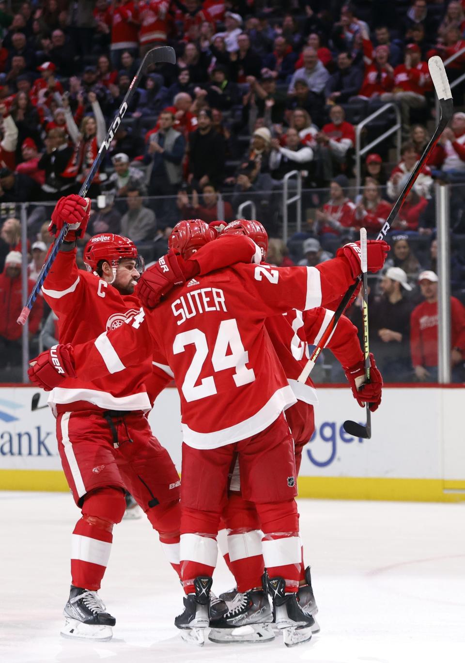 Detroit Red Wings center Pius Suter (24) celebrates with teammates, including center Dylan Larkin, left, after scoring against the Colorado Avalanche during the first period of an NHL hockey game Saturday, March 18, 2023, in Detroit. (AP Photo/Duane Burleson)