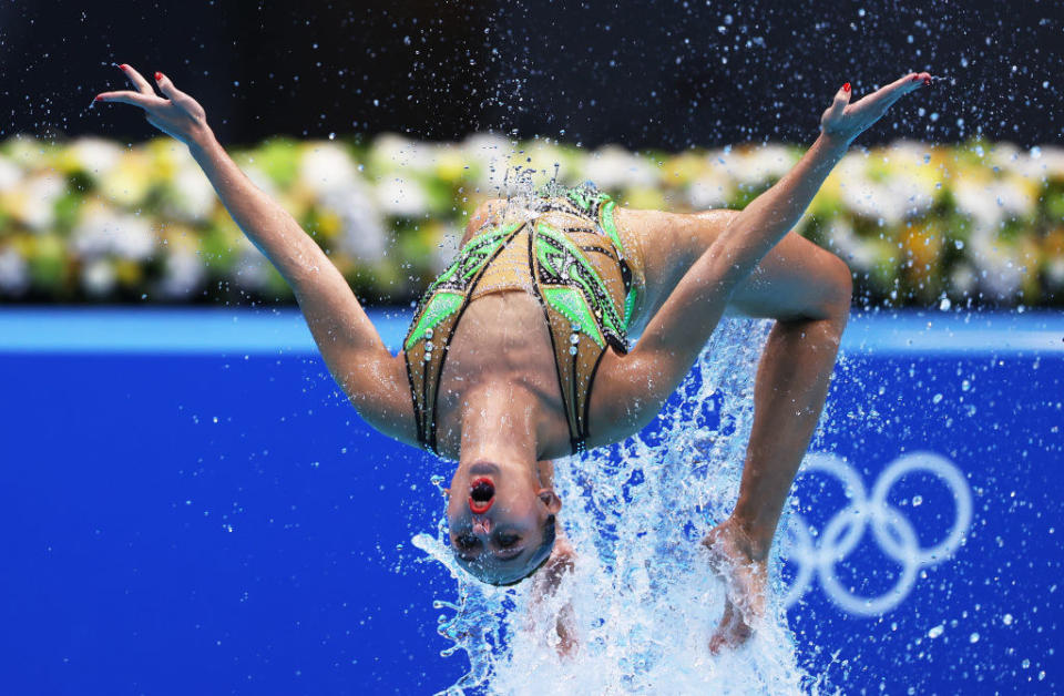 A swimmer doing a backflip with arms raised