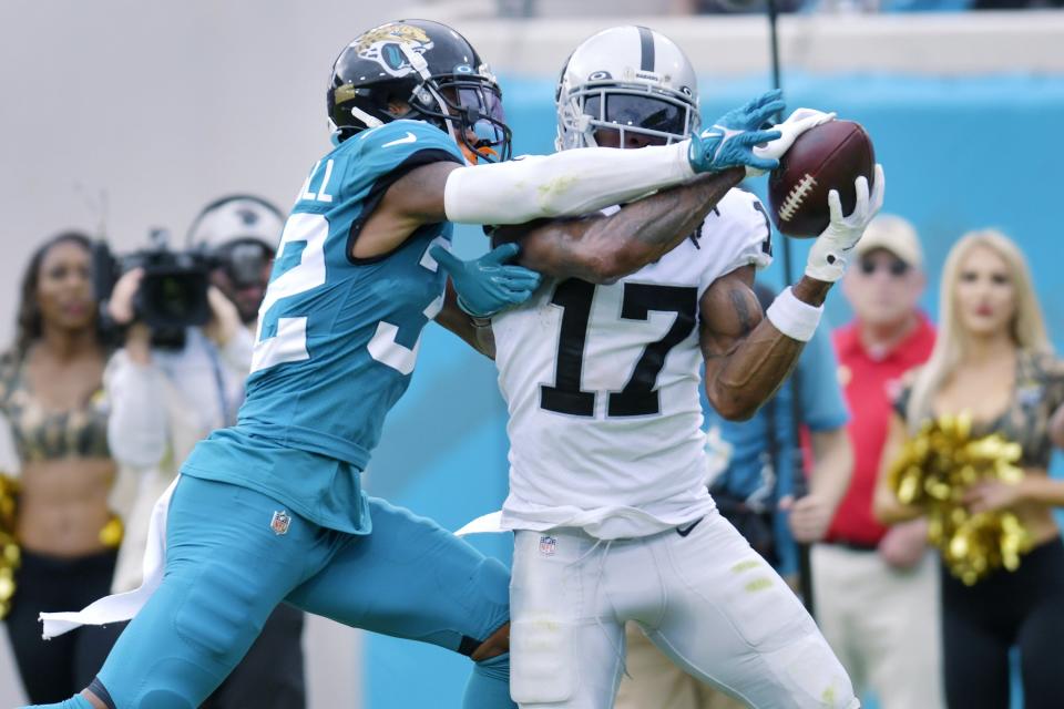 Jaguars cornerback Tyson Campbell (left) helped hold Las Vegas Raiders wide receiver Davante Adams (17) to one reception for a net of zero yards in the second half of the Jags' 27-20 victory.