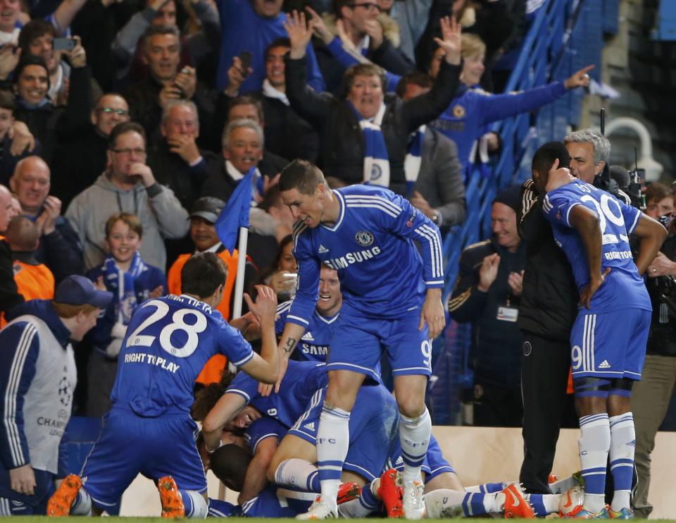 Chelsea's Demba Ba celebrates with coach Jose Mourinho and team mates after scoring the second goal for the team during their Champions League quarter-final second leg soccer match against Paris St Germain at Stamford Bridge in London