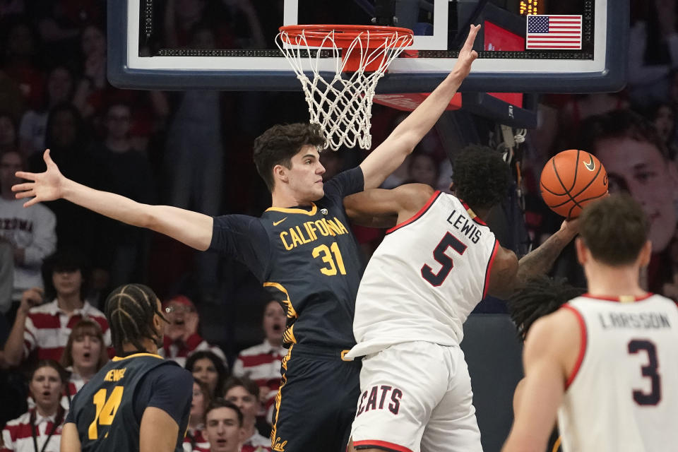 Arizona's KJ Lewis (5) scores on California's Gus Larson (31) during the first half of an NCAA college basketball game Thursday, Feb. 1, 2024, in Tucson, Ariz. (AP Photo/Darryl Webb)