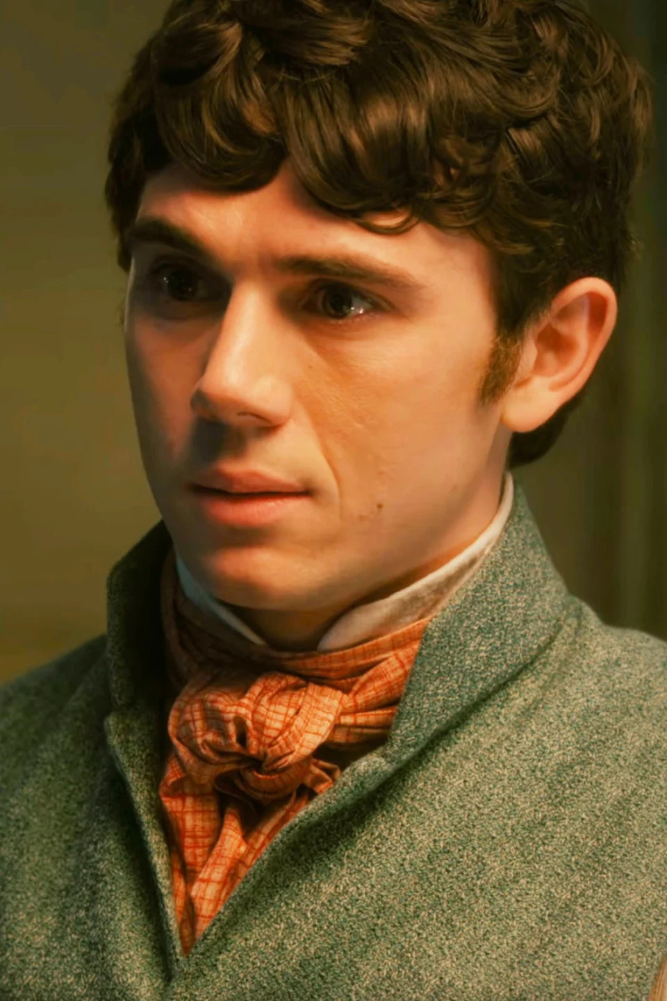 Calam Lynch as Theo Sharpe, dressed in 19th-century attire, featuring a high-collared shirt, cravat, and waistcoat from the TV series Bridgerton