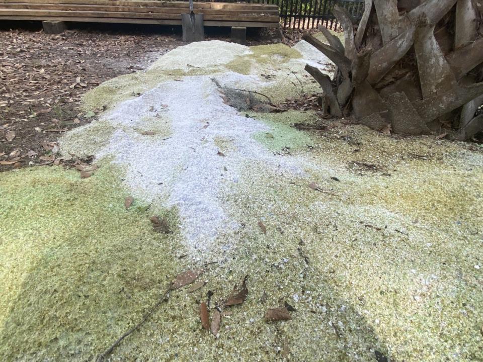 Different piles of sand demonstrate where Buttrey has experimented with different styles of grinding glass.