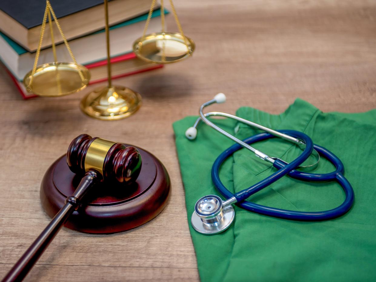 A gavel and a stethoscope on a wooden table concept of medical and legal industries.