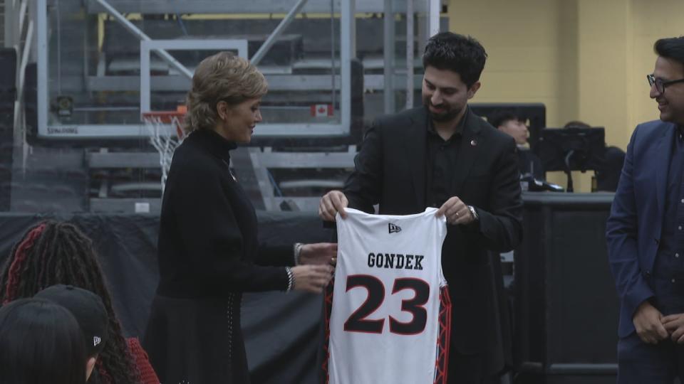 Jason Ribeiro, the vice-chairman and president of the Calgary Surge, presents a Surge jersey to calgary Mayor Jyoti Gondek at a celebration of the team's first anniversary Thursday at the WinSport Event Centre.